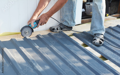 Roofing Construction Worker Cutting Corrugated Metal Roofing Sheet with Angle Grinder