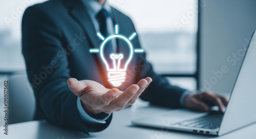 Business professional holding glowing lightbulb idea concept in modern office