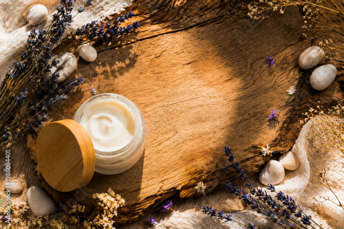 Natural organic cream jar with lavender and smooth stones on a rustic wooden background