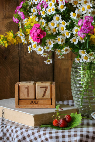July 17th. calendar and bouquet of garden flowers in vase. festive event or birthday.