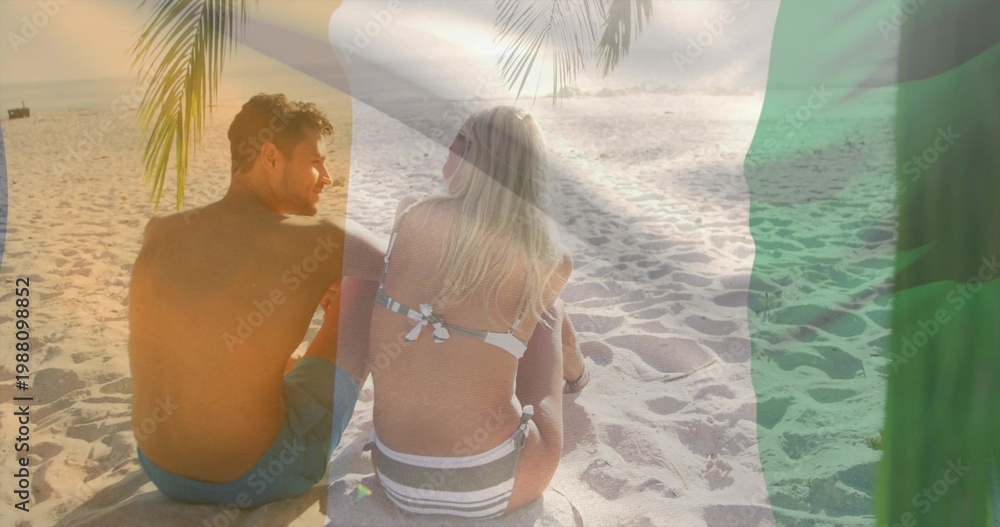 Obraz premium Sitting couple chatting, facing ocean at beach in swimwear on mat, palm frond, green overlay