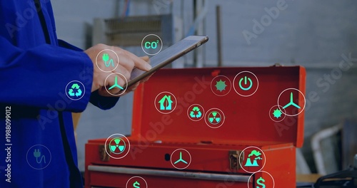 Holding tablet, tech blue-jacketed tapping screen in workshop, red tool chest, AR icons, copy space