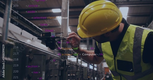 Fotografie Adjusting tech tightening clamp on rail at plant, in hardhat and vest, code over