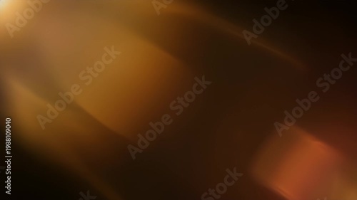 Golden orange lens flare on dark black background