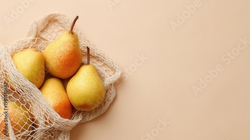 Fresh pears and one red fruit in a white mesh shopping bag, representing sustainable living and food choices natural healthy