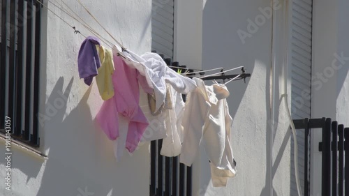 Clothes drying on a line outside a building during a sunny day