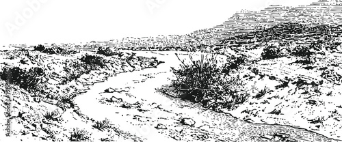 Winding creek flowing through a rocky natural landscape with sparse shrubbery and hills