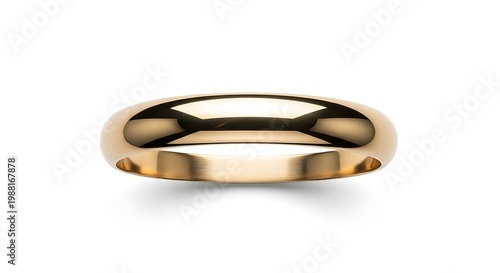 A gold ring sits isolated on a surface with a shiny bracelet