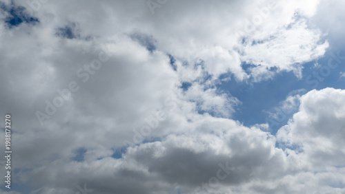 Wide aerial shot of white clouds in blue sky above land