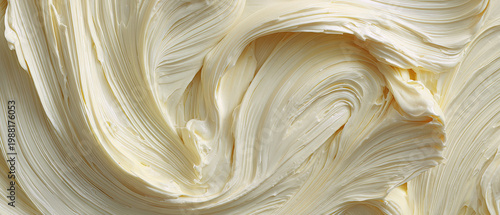 Close up of smooth, swirled butter with rich texture and creamy yellow color, perfect for food backgrounds or culinary advertisements.
