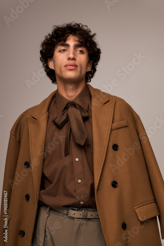 Canvastavla Stylish young man showcases modern fashion with elegance in a warm color palette