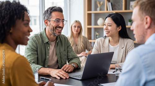 Tableau sur toile Diverse professional colleagues smiling and collaborating during an informal business meeting in a bright modern office