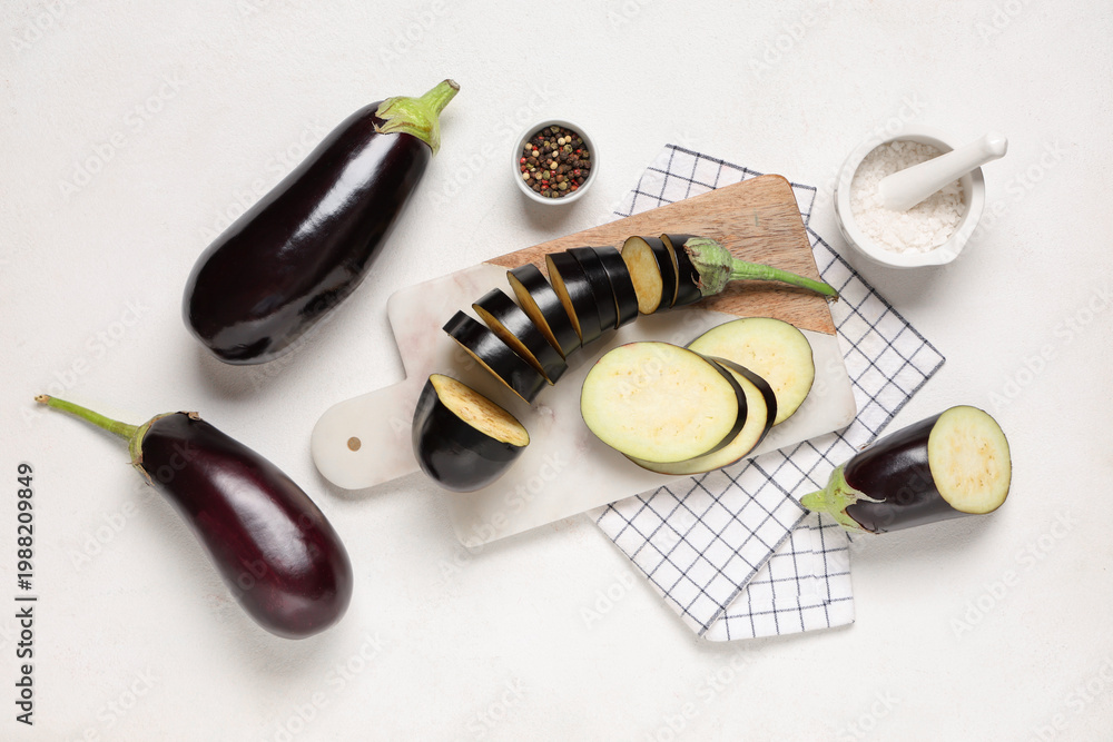 Obraz premium Composition with cut fresh eggplants, cutting board and napkin on white background