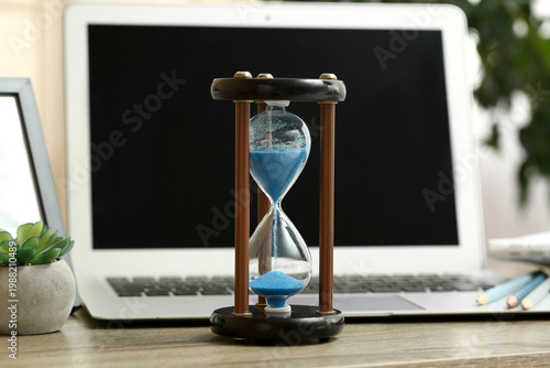 Hourglass with laptop and s...