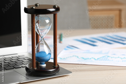 Hourglass with laptop and d...