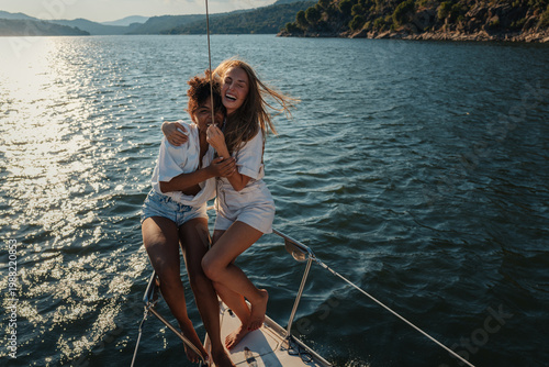 Cuadro en lienzo Happy young women embracing on sailing boat