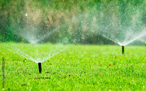 Photos Automatic lawn sprinkler watering green grass in garden with adjustable head system, irrigation technology for water conservation and efficient landscape maintenance, outdoor residential yard care