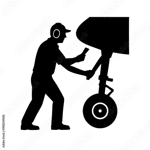 Black silhouette of a man pushing a large object on a dolly