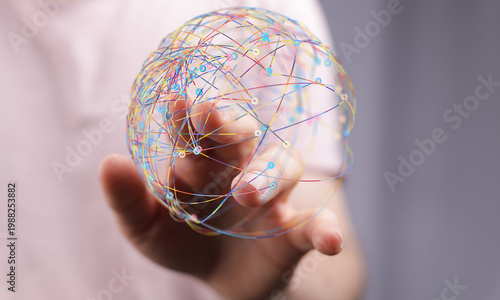 Hand holding a globe with digital lines representing a global network, concept of connection and technology. Ideal for b