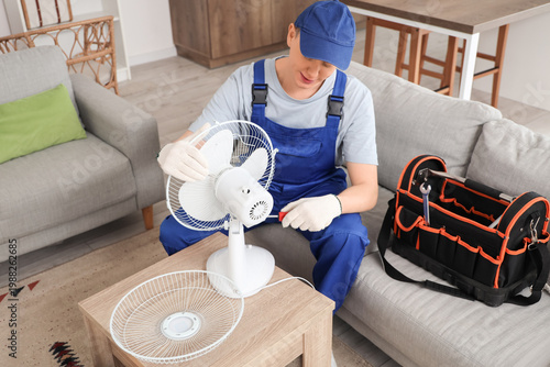 Male technician repairing e...