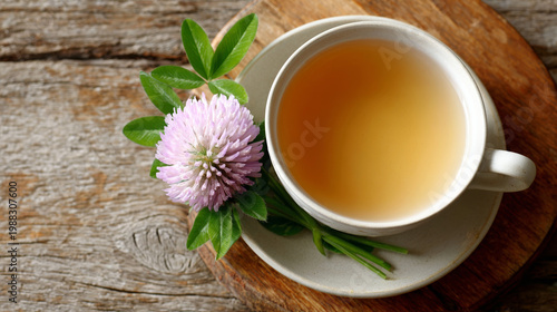 Herbal tea in a white cup with purple flower on wooden table  
