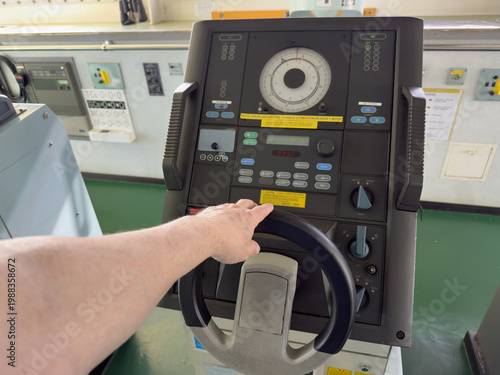 helmsman steering course. cargo ship proceeding enroute. navigation bridge watch and equipment