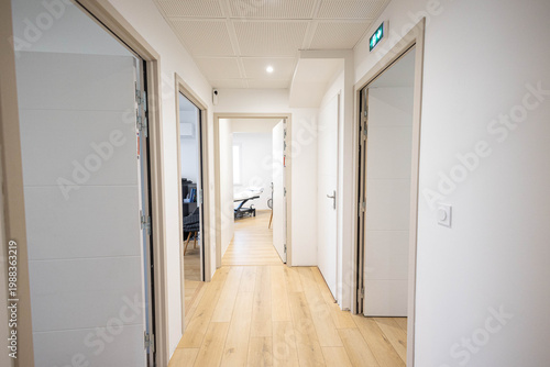 Un cabinet médical neuf avec 5 portes ouvertes, un parquet en bois. L'intérieur est très lumineux