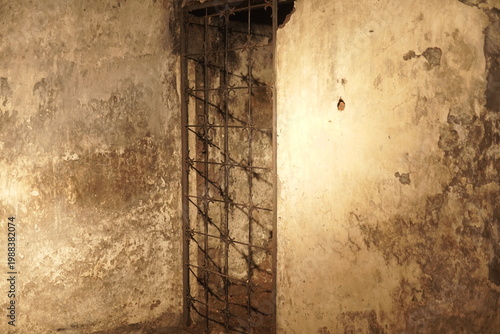 Tableau sur toile A rusted iron gate in a dark, heavily distressed concrete dungeon cell