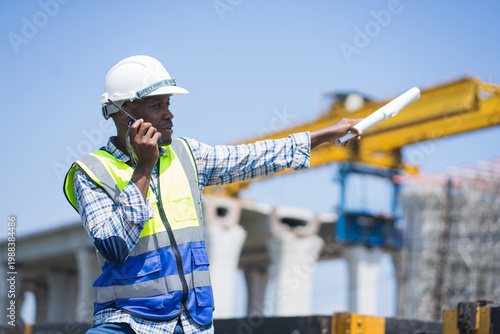 Professional worker in safety gear managing logistics at railway construction
