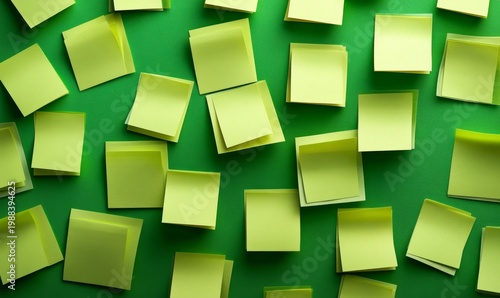 Scattered Yellow Sticky Notes on Green Background - Creative Workspace Concept