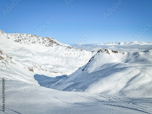 Alpine Serenity: Snowy Mountain Peaks Under a Clear Blue Sky