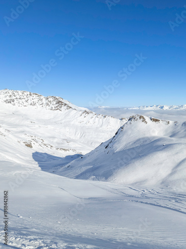 Alpine Serenity: Snowy Mountain Peaks Under a Clear Blue Sky