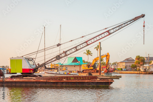 A crane on a floating barge in Naples Bay, Florida