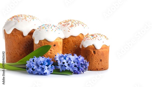 Group of traditional festive baked goods, topped with white icing and colorful sprinkles, next to blue flowers