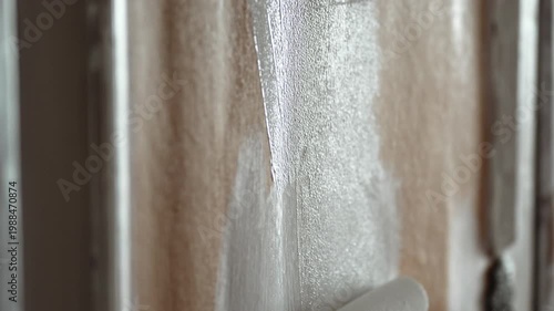 Close-up of Man Painting Old Wooden Door with Paint Roller, Home Renovation and Restoration Process, 4K 10-bit