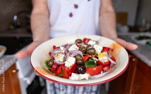 Photos Woman holding a bowl of fresh traditional Greek salad