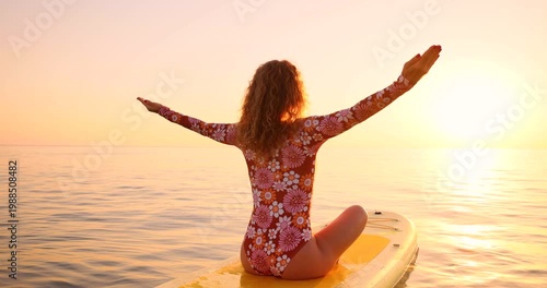 A happy young woman walking on a sup board by the sea during her summer vacation. Slow motion