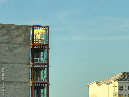 Warm light from the setting sun illuminates a top corner unit of a multistory senior living facility under construction, along with top corner of another building in progress, in southwest Florida