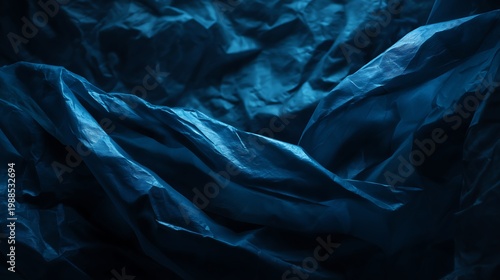 Wet crumpled blue plastic bag texture dark reflective surface abstract background