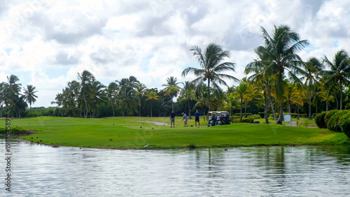 Cuadro en lienzo Group of golfers preparing to tee off on a lush green golf course surrounded by