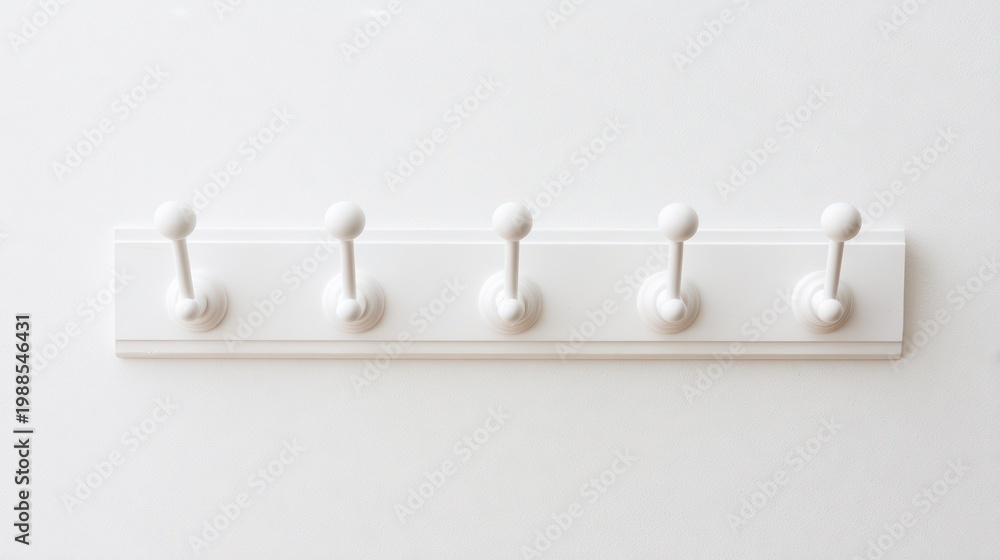 Obraz premium White coat rack with five hooks against a bright wall background