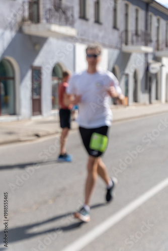 Wallpaper Mural Motion-blurred athletic man running marathon on urban street Torontodigital.ca