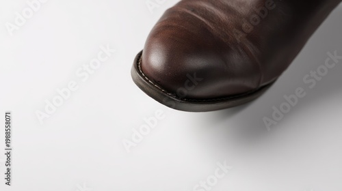 Close up of a brown leather boot on a clean white surface