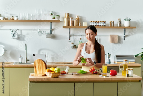 Valokuva Young woman prepares a vibrant salad with fresh vegetables in her stylish kitche