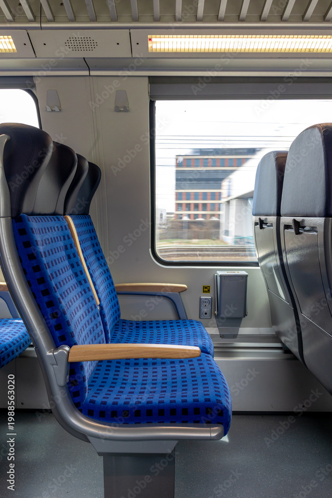 Obraz premium empty train compartment with blue seats and window showing building through blurred motion, modern design