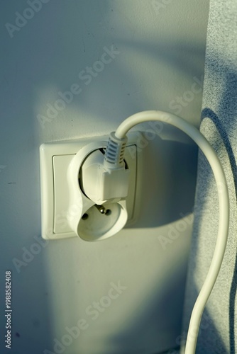 Closeup Of Electrical Outlet With Plugged Device. Detailed View Of Wall Socket With Attached Electrical Plug