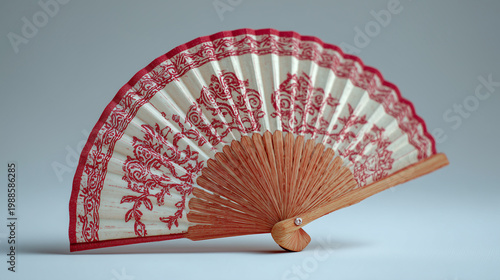 Traditional bengali hand fan with red and white pattern