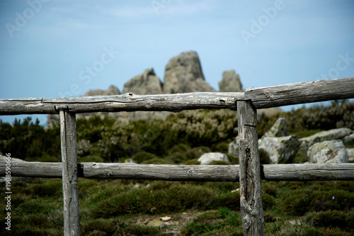 Fotografie a wooden fence overlooking the rocky landscape of the Mount Limbara near Berchidda in Sardinia, Italy