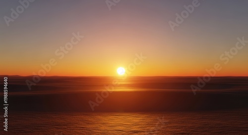 Sunset over the ocean with a vibrant orange sky and calm water
