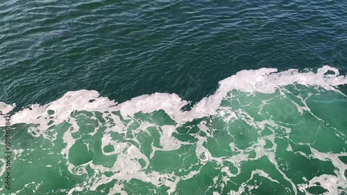 At Sea - View of the sea with waves. Horizon and distant mountains are present during the maritime crossing on the ocean. Travel and holiday concept.